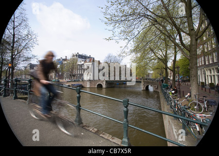 Straßenszene, ein Fahrrad überqueren einer Brücke in einen Kanal von Amsterdam, Niederlande Stockfoto