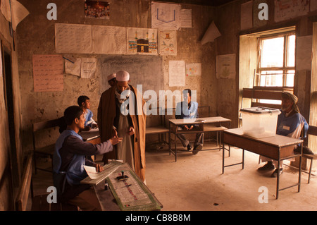 Ein afghanischen Wähler wirft seinen Stimmzettel in einem Wahllokal in Kabul, Afghanistan, Oktober 2004 Stockfoto