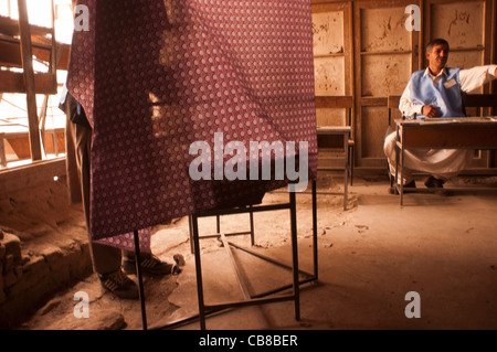 Ein Wähler wirft seinen Stimmzettel in einem Wahllokal in Kabul, Afghanistan, Oktober 2004 Stockfoto