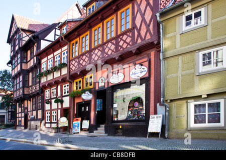 Eine Reihe von mittelalterlichen Fachwerkhäusern in einer gepflasterten Straße in die UNESCO-Welterbe-Stadt Quedlinburg, Deutschland. Stockfoto