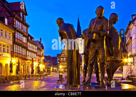 Dämmerung im Marktplatz oder Platz, der Markt in Quedlinburg, Deutschland mit Statue des Amtsgebietes Musiker im Vordergrund. Stockfoto