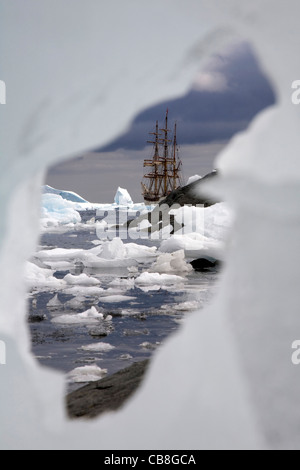 Mottenhalle Europa, ein Dreimaster Viermastbark gesehen durch Lücke im Eisberg im antarktischen Meer bei Port Charcot, Antarktis Stockfoto