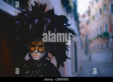 Karneval atmosphärischen Maske Seitenstraße Dämmerung Licht im traditionellen Venezianischen gefiederten Kopfstück und Maske für Karneval in Venedig Italien Stockfoto