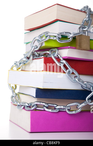 Stapel von bunte Bücher, geschützt mit einer Kette (auf einem weißen Hintergrund) Stockfoto