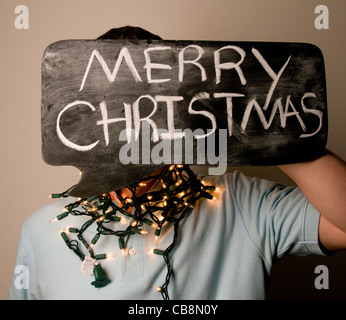 Mann mit Frohe Weihnachten Schild auf Tafel Blase. Stockfoto