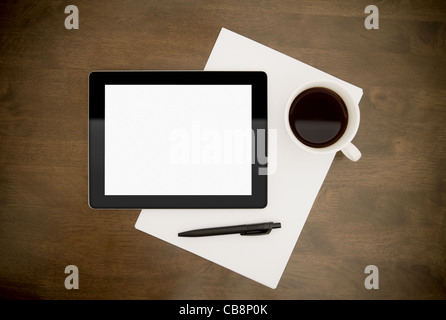 Leere digital-Tablette mit Papier, Stift und Tasse Kaffee am Arbeitstisch. Ansicht von oben. Stockfoto