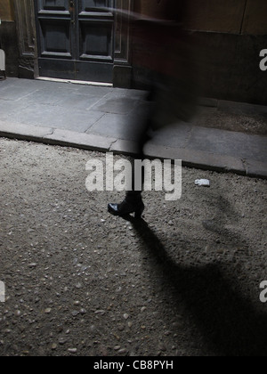 Person, die nachts in dunklen Gasse Stockfoto