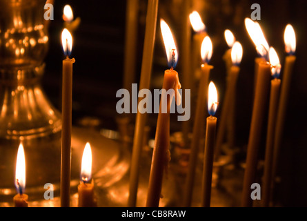 Foto von brennenden Kerzen in der Kirche mit dunklem Hintergrund Stockfoto