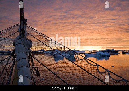 Bugspriet mit Sicherheit Netting und Sonnenuntergang über den argentinischen Inseln gesehen vom Segelschiff, Antarktis Stockfoto