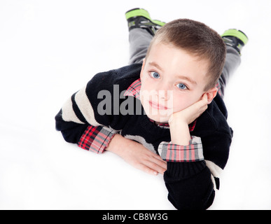 Kleiner Junge Handauflegen Magen mit Kinn ruht in der Hand im Studio isoliert auf weiss Stockfoto