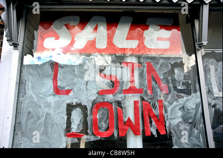 Eine leere Schaufenster in eine s London High Street mit einem ' Schließung ' Verkaufsschild auf seinen weißen gewaschen Fenster. Stockfoto