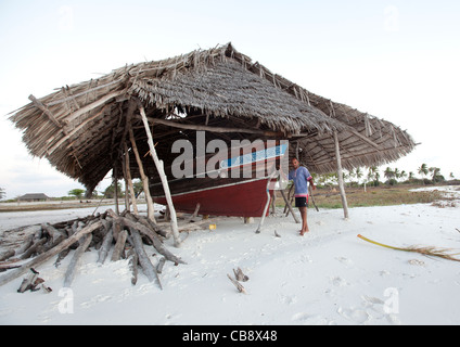 Werft an einem Strand mit Palmendach, ein Mann stehend, Lamu, Kenia Stockfoto