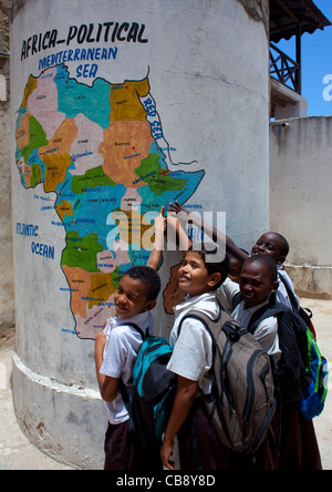 Gruppe von männlichen Schülern zeigen Lamu auf bemalte Karte in der Schule, Lamu, Kenia Stockfoto