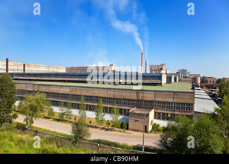 Große Fabrik mit rauchenden Schornsteine gegen den blauen Himmel Stockfoto