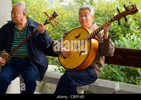 Zwei Männer spielen eine chinesische Banjo und Ruan in einem Orchester im Freien im Zizhuyuan lila Bambus Park in Peking Volksrepublik China Stockfoto