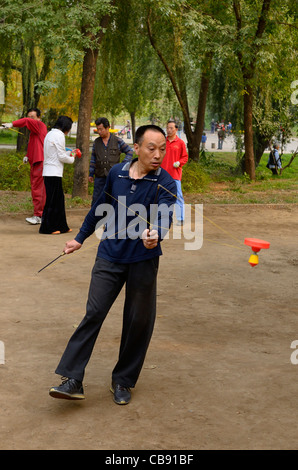 Man spinnen eine chinesische Yo Yo in zizhuyuan lila Bambus Park in Peking, Volksrepublik China Stockfoto