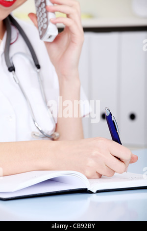 Nahaufnahme auf ziemlich kaukasischen schreiben Ärztin per Telefon sprechen. Stockfoto