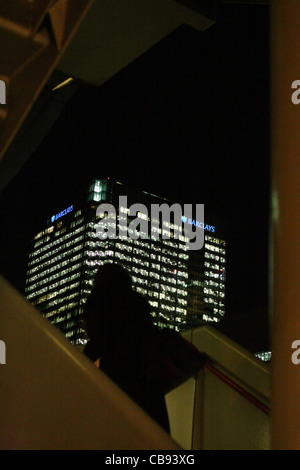 eine Silhouette einer Frau beim Treppensteigen Pappel Bahnhof London, mit Barclays Bank Hauptsitz in der Rückseite geschliffen Stockfoto
