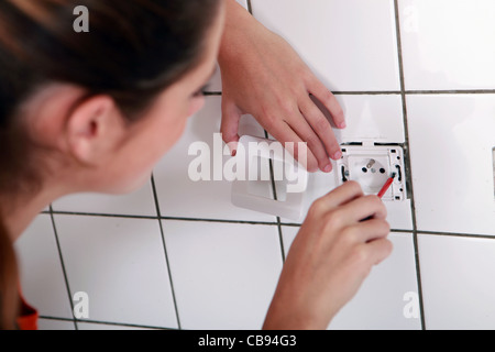 Frau, die Festsetzung einer Steckdose Stockfoto