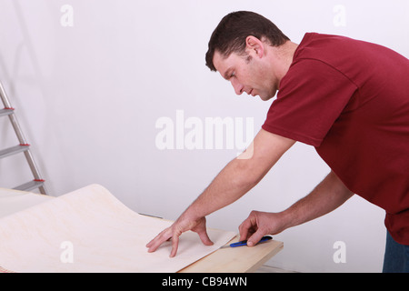 Kaufmann, schneiden ein Blatt Papier Stockfoto