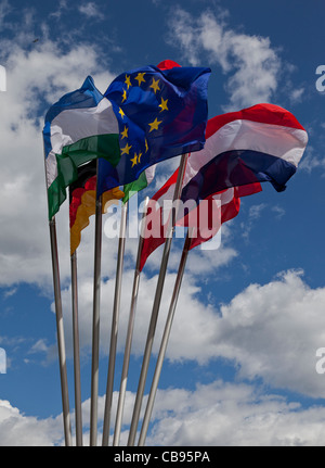Eine Gruppe von 7 europäischen Fahnen flattern im Wind gegen blauen Himmel und Wolken Stockfoto