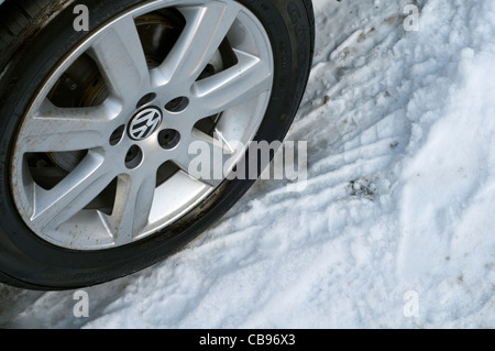 Detail des Reifens eines Autos auf einer verschneiten Straße geparkt Stockfoto