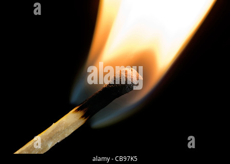 hölzerne Streichholz anzünden in Flammen auf schwarzem Hintergrund Stockfoto