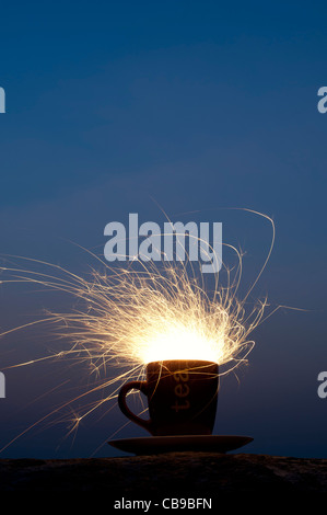 Fiery Sturm im Wasserglas Konzept. Fire Cracker in einer Schale, die in der Nacht Stockfoto