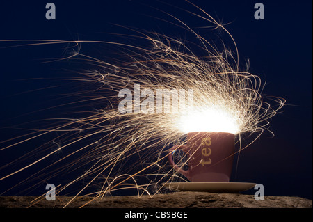 Fiery Sturm im Wasserglas Konzept. Fire Cracker in einer Schale, die in der Nacht Stockfoto