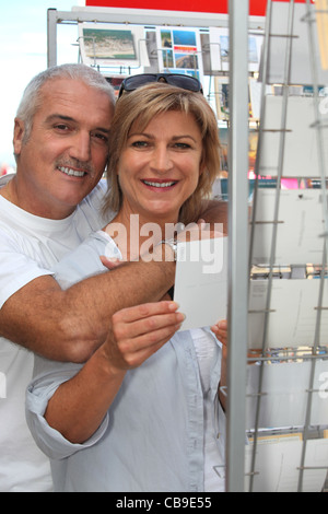 Touristen, die Postkarten durchsuchen Stockfoto