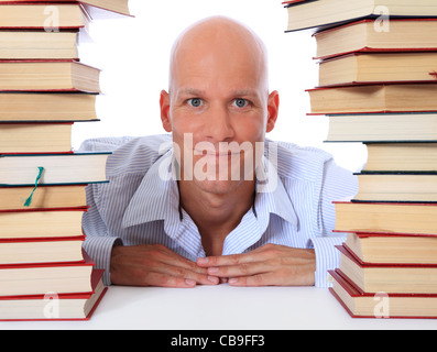 Attraktive Mitte Alter Mann zwischen zwei Stapel von Büchern. Alle auf weißem Hintergrund. Stockfoto