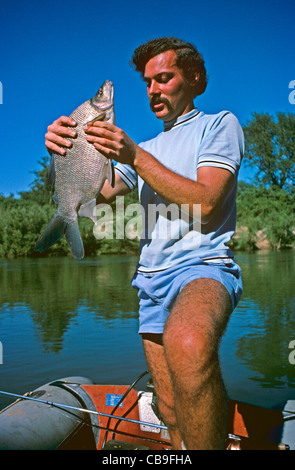 Fischer auf einen afrikanischen Fluss mit einem Fisch lokal bekannt als "Chessa" (Distichodus Schenga) Stockfoto