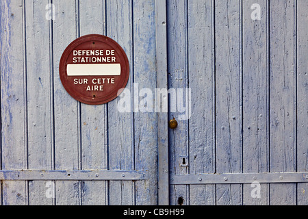 Keine Wartezeit Verteidigung de Stationner verblasst Schild am Garage Tür Camares Stadt Frankreich Stockfoto