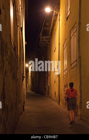 Frau allein zu Fuß in einer engen Gasse bei Nacht Camares France Stockfoto