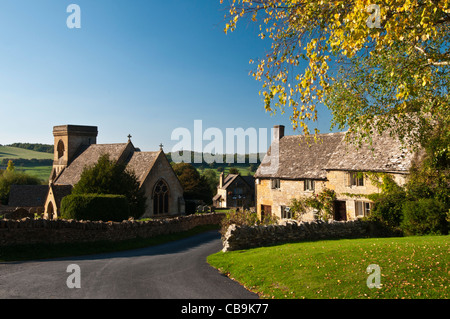 Hütten gebaut von Cotswold Stein neben St. Barnabas Church in Cotswolds Dorf von Snowshill mit Blick auf die Landschaft, Gloucestershire, England Stockfoto