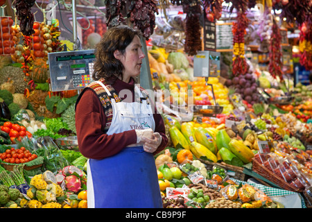 Frau verkaufen frisches Obst und Gemüse im Stall auf dem La Boqueria-Markt in Barcelona, Spanien Stockfoto