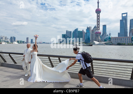 Chinesische Hochzeit Braut und Bräutigam am Bund Wasser posiert vor dem Oriental pearl Gebäude Shanghai VR China Asien Stockfoto