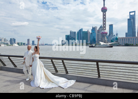 Chinesische Hochzeit Braut und Bräutigam am Bund Wasser posiert vor dem Oriental pearl Gebäude Shanghai VR China Asien Stockfoto