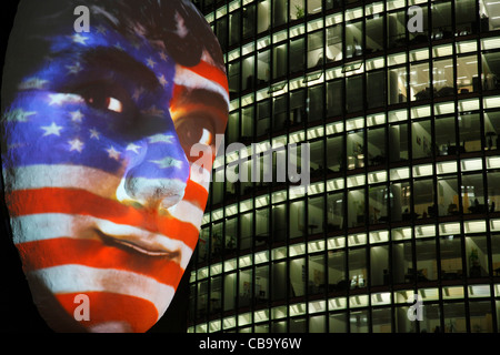 Riesige Skulptur eines Gesichts beleuchtet durch ein Bild von einer US-Flagge bemaltem Gesicht beim Festival der Lichter 2011 in Berlin Stockfoto