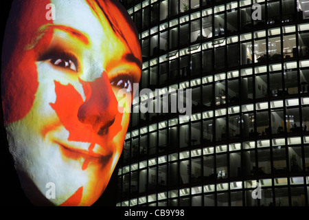 Riesige Skulptur eines Gesichts beleuchtet durch ein Bild einer kanadischen Flagge bemaltem Gesicht während des Festival of lights 2011 in Berlin Stockfoto