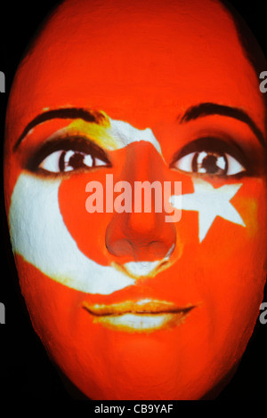 Riesige Skulptur eines Gesichts beleuchtet durch ein Bild von einer türkischen Fahne bemaltem Gesicht während des Festival of lights 2011 in Berlin Stockfoto