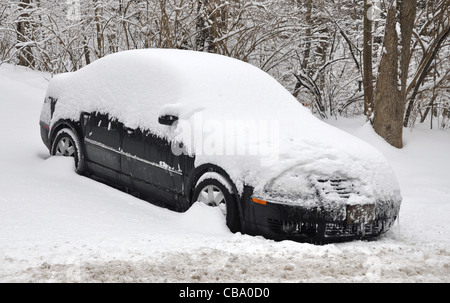 Auto auf einem Hügel während eines Sturms im Schnee begraben Stockfoto