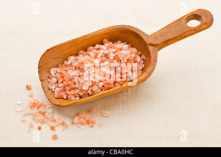 grobe Kristalle von rosa und orange Himalayasalz auf rustikalen hölzernen Schaufel Stockfoto