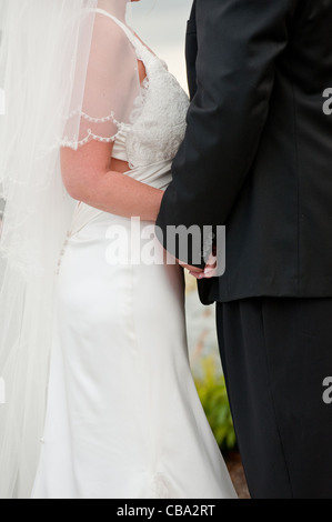 Braut und Bräutigam Hand in Hand während der Trauung Stockfoto