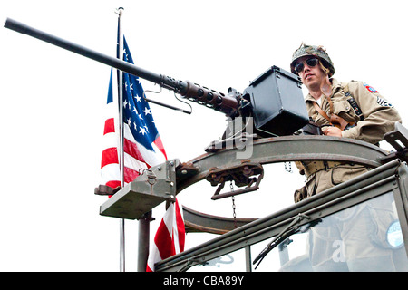 Re-Enactor gekleidet wie ein WWII amerikanische GI deaktiviert Maschinengewehr Mans auf einem erhaltenen Kriegszeit Vintage US Army LKW montiert Stockfoto