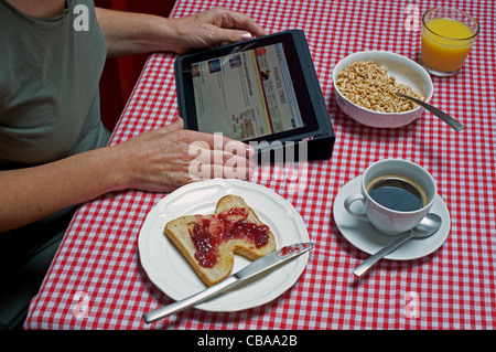 Frau liest Online-Ausgabe der Financial Times auf ein Apple iPad Tablet-computer Stockfoto