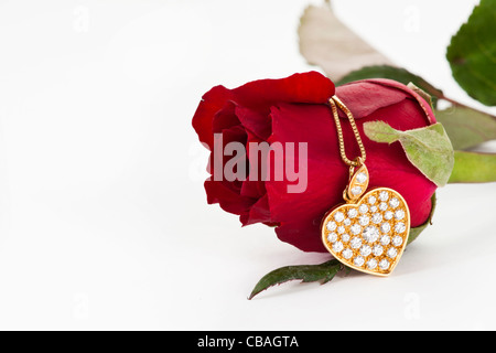 Herz-Anhänger mit Diamanten und rote Rose auf weißem Hintergrund Stockfoto