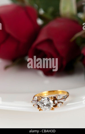 Goldenen Diamantring und Rose auf weißem Hintergrund Stockfoto