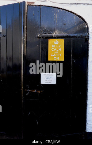 Die bekannte britische Moral Förderung von Weltkrieg zwei Slogan "Keep Calm and Carry On" Schild auf einer alten Holztür. Stockfoto