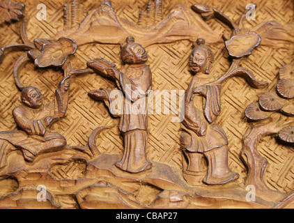 Asiatische geschnitzte Holzplatte Detail mit drei Personen Stockfoto